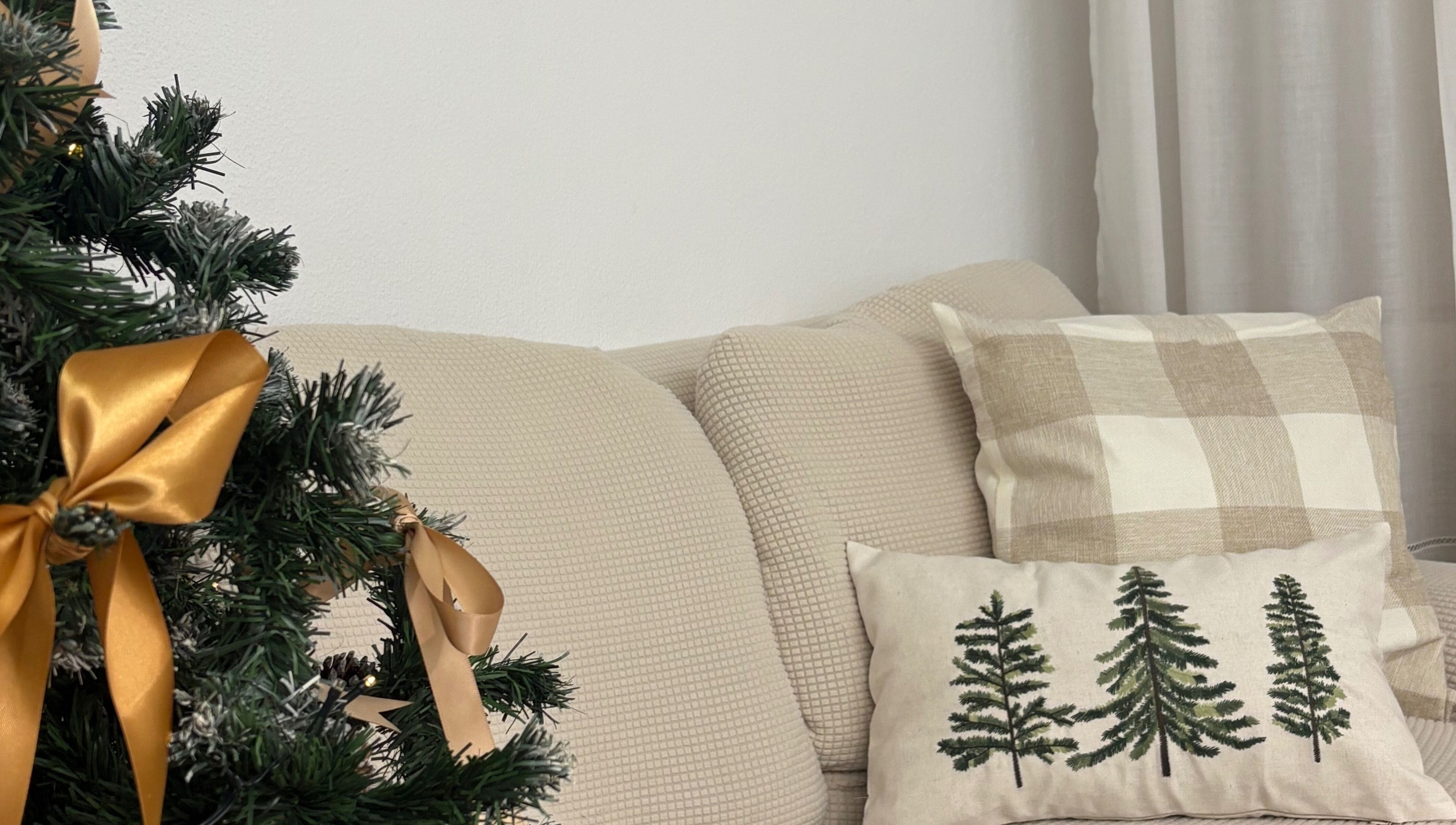 Ambiente natalino acolhedor em Esthetics by Rita, Moreira, Porto, PT, com almofadas e árvore decorada.
