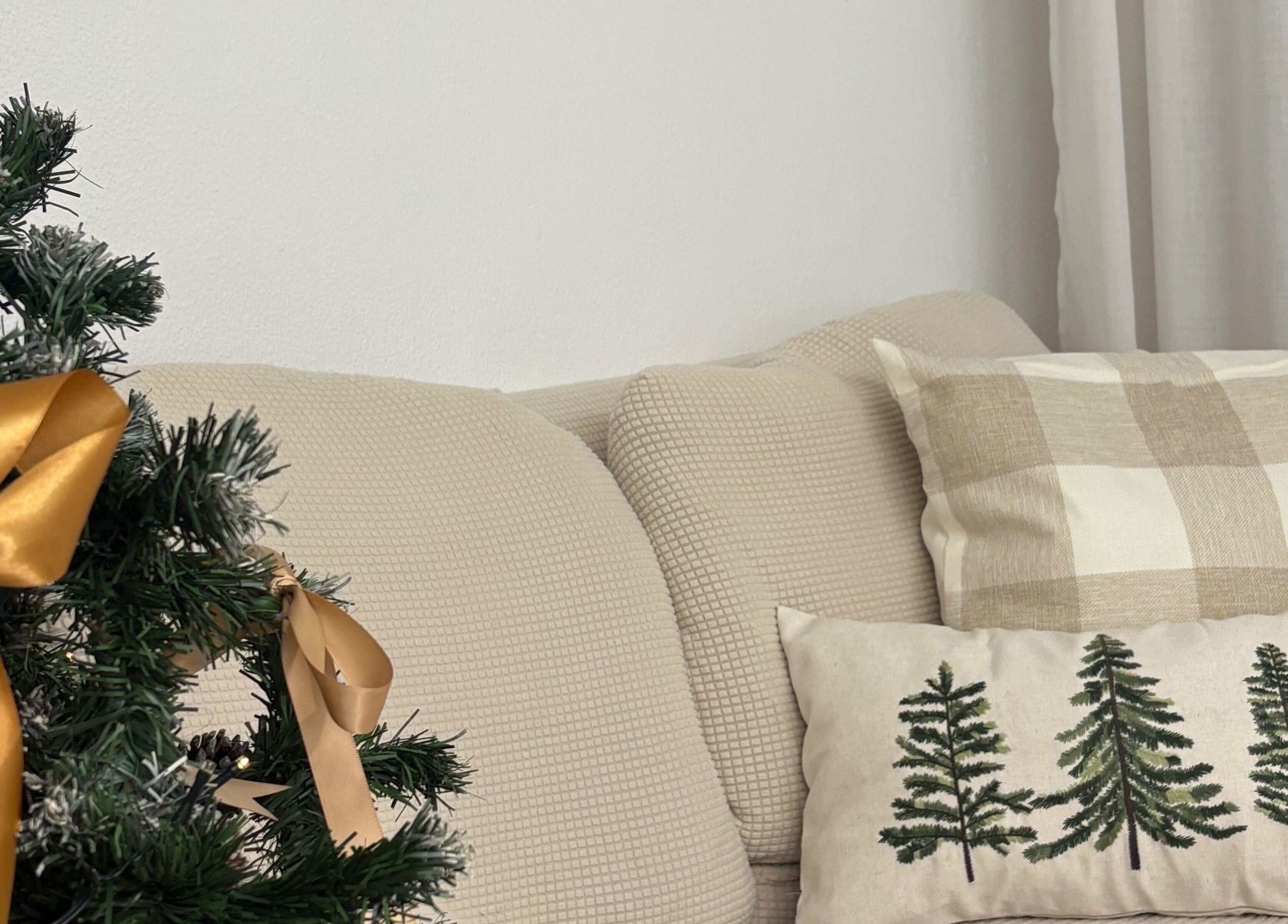 Ambiente natalino acolhedor em Esthetics by Rita, Moreira, Porto, PT, com almofadas e árvore decorada.