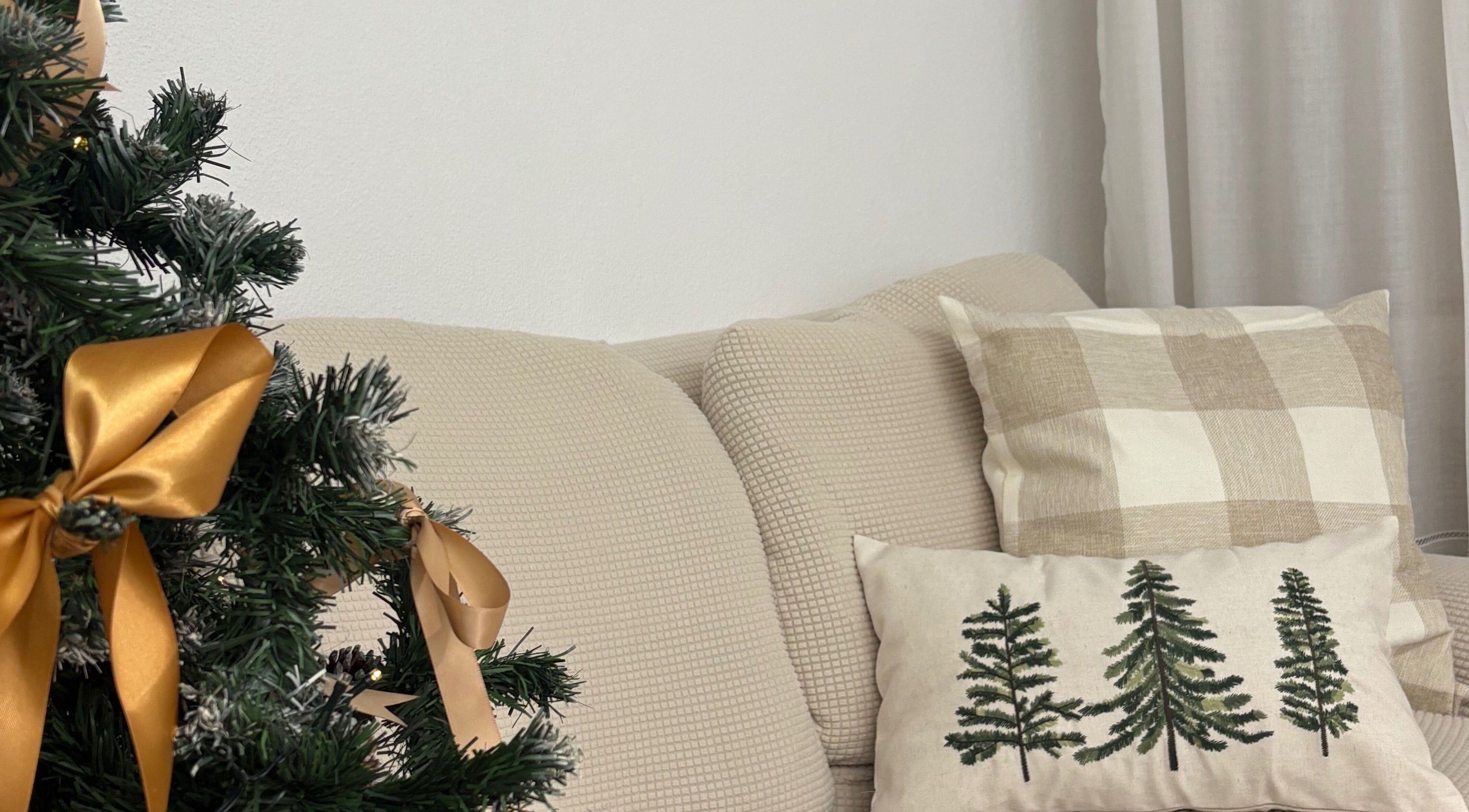 Ambiente natalino acolhedor em Esthetics by Rita, Moreira, Porto, PT, com almofadas e árvore decorada.