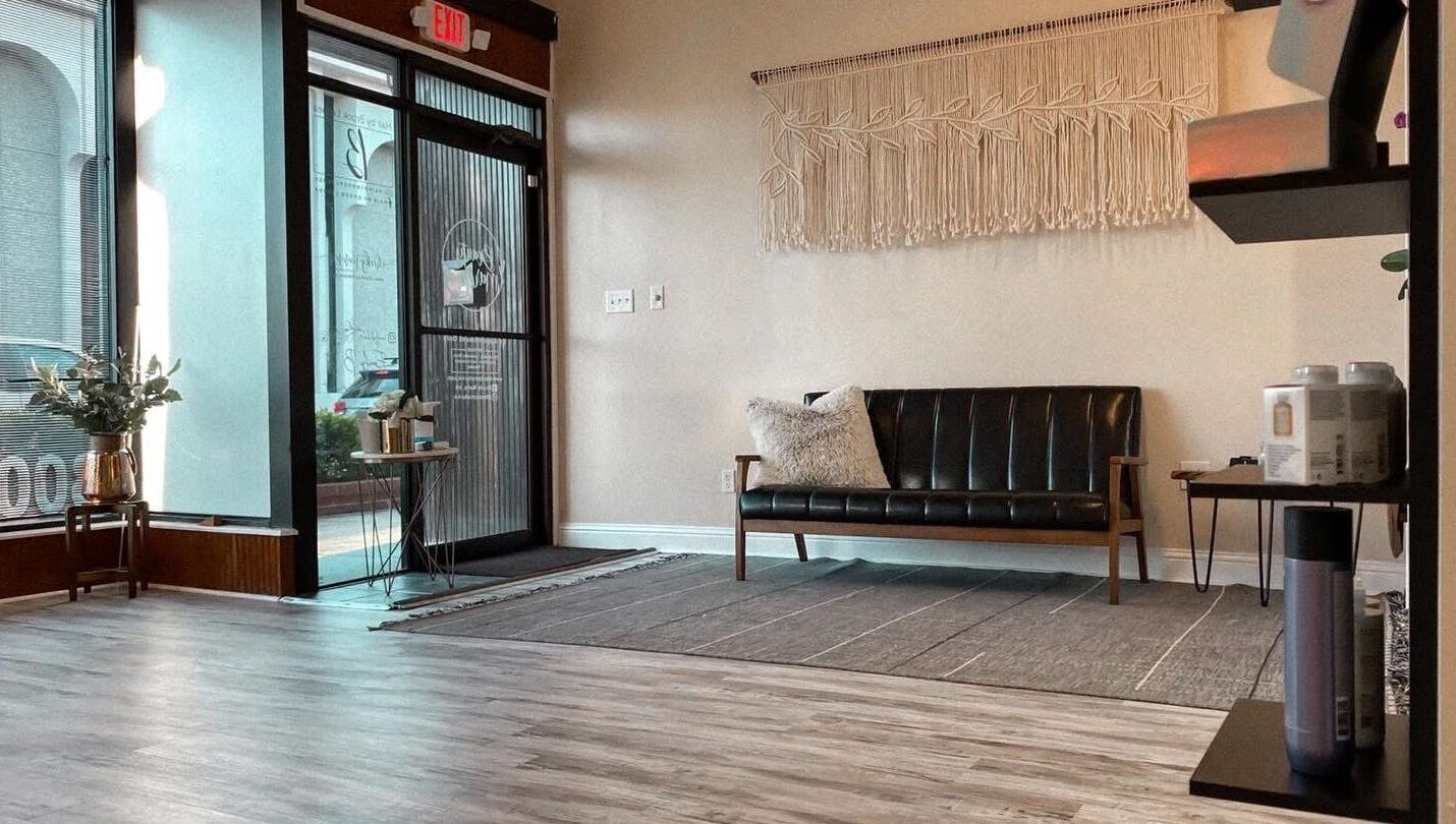 Elegant waiting area at Salted Stone Aesthetics By Macie, Murray, Kentucky, US, featuring a modern black sofa.