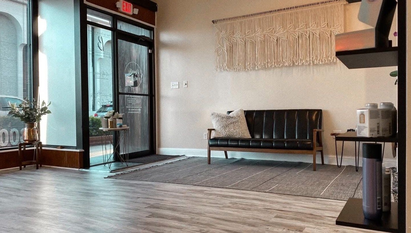 Elegant waiting area at Salted Stone Aesthetics By Macie, Murray, Kentucky, US, featuring a modern black sofa.