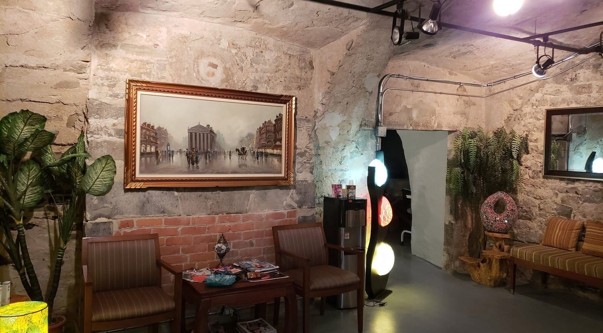 La peau de Soie's cozy lounge with stone walls in Montréal, Québec, CA features warm lighting and eclectic decor.