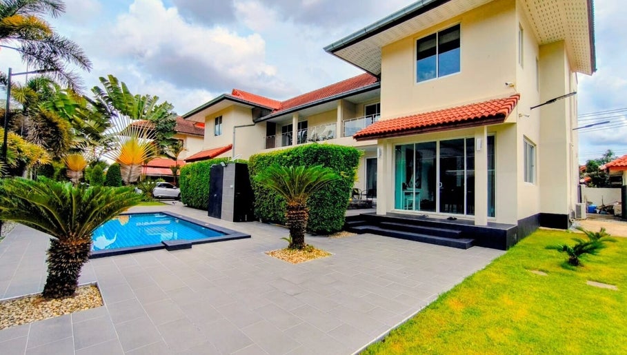 Outdoor pool at Reevitalise Wellness, Muang Pattaya, Chang Wat Chon Buri, TH with lush garden landscaping.