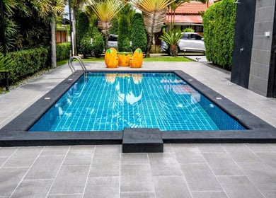 Relax by the serene pool at Reevitalise Wellness, Muang Pattaya, Chang Wat Chon Buri, TH, surrounded by lush greenery.