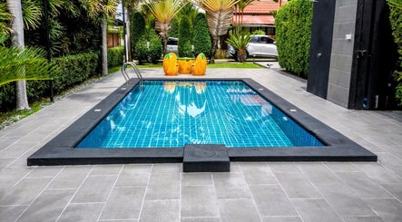 Relax by the serene pool at Reevitalise Wellness, Muang Pattaya, Chang Wat Chon Buri, TH, surrounded by lush greenery.