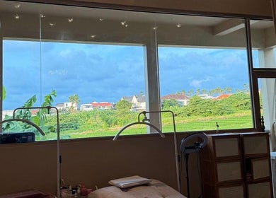 Relaxing spa room at Sara Anna Spa, Bali, Bali, ID with scenic green field view through large windows.