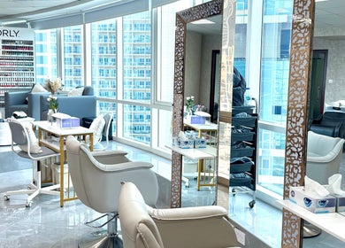 Elegant interior of Rosemarie Beauty Centre in Dubai, AE, showcasing modern chairs and nail polish display.