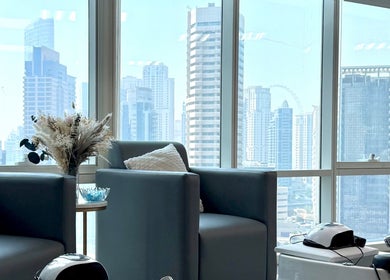 Relaxing lounge view at Rosemarie Beauty Centre, Dubai, AE, showcasing skyline through large windows.