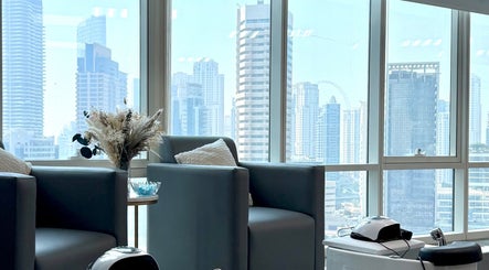 Relaxing lounge view at Rosemarie Beauty Centre, Dubai, AE, showcasing skyline through large windows.
