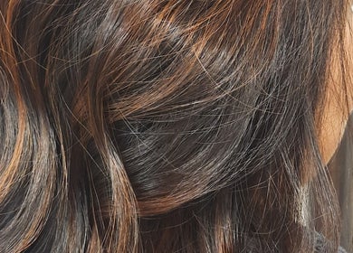 Close-up of highlighted hair at R.M, London, England, GB showcasing vibrant brown tones.