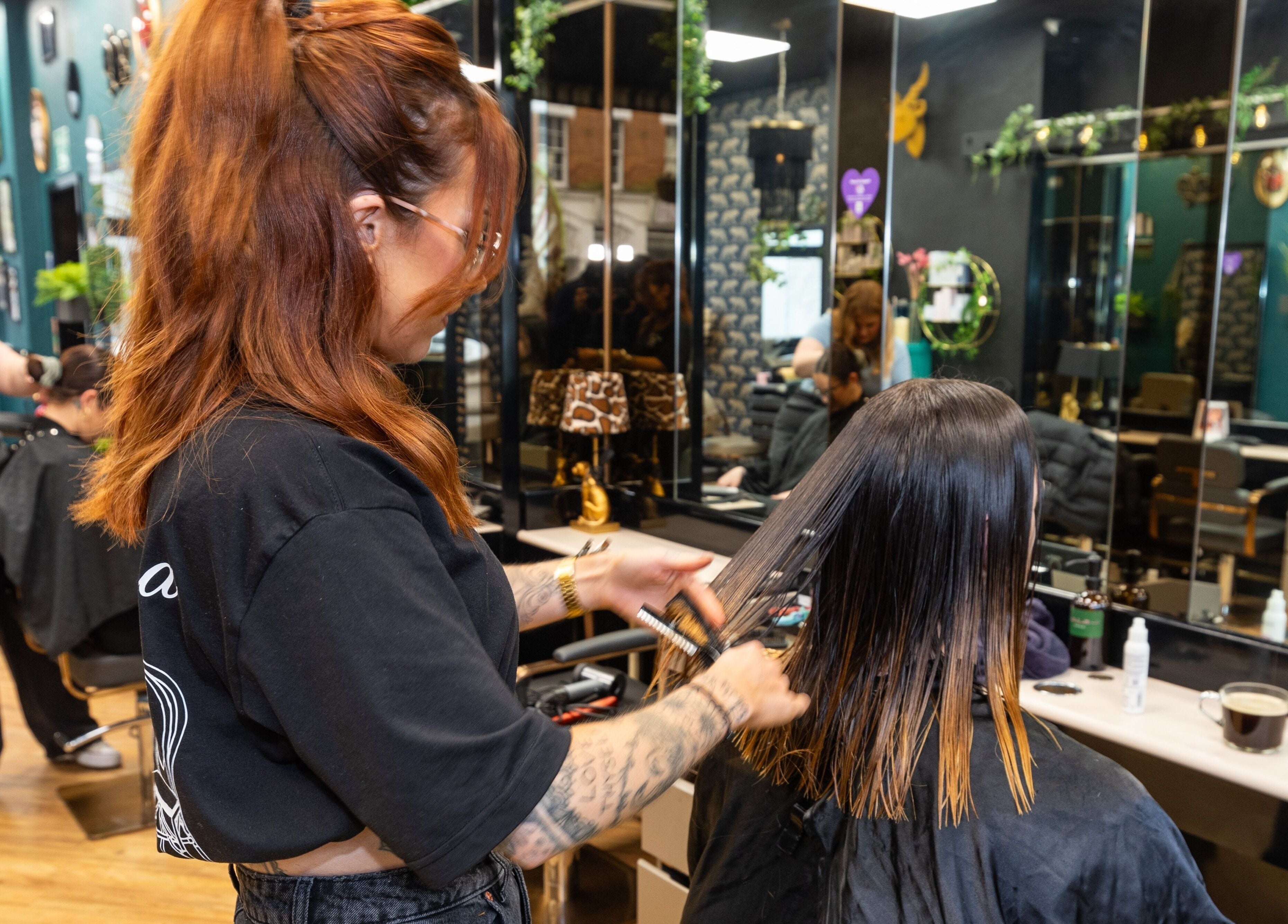 Hairdresser styling hair at The Knott in Folkestone, England, GB, stylish salon interior.