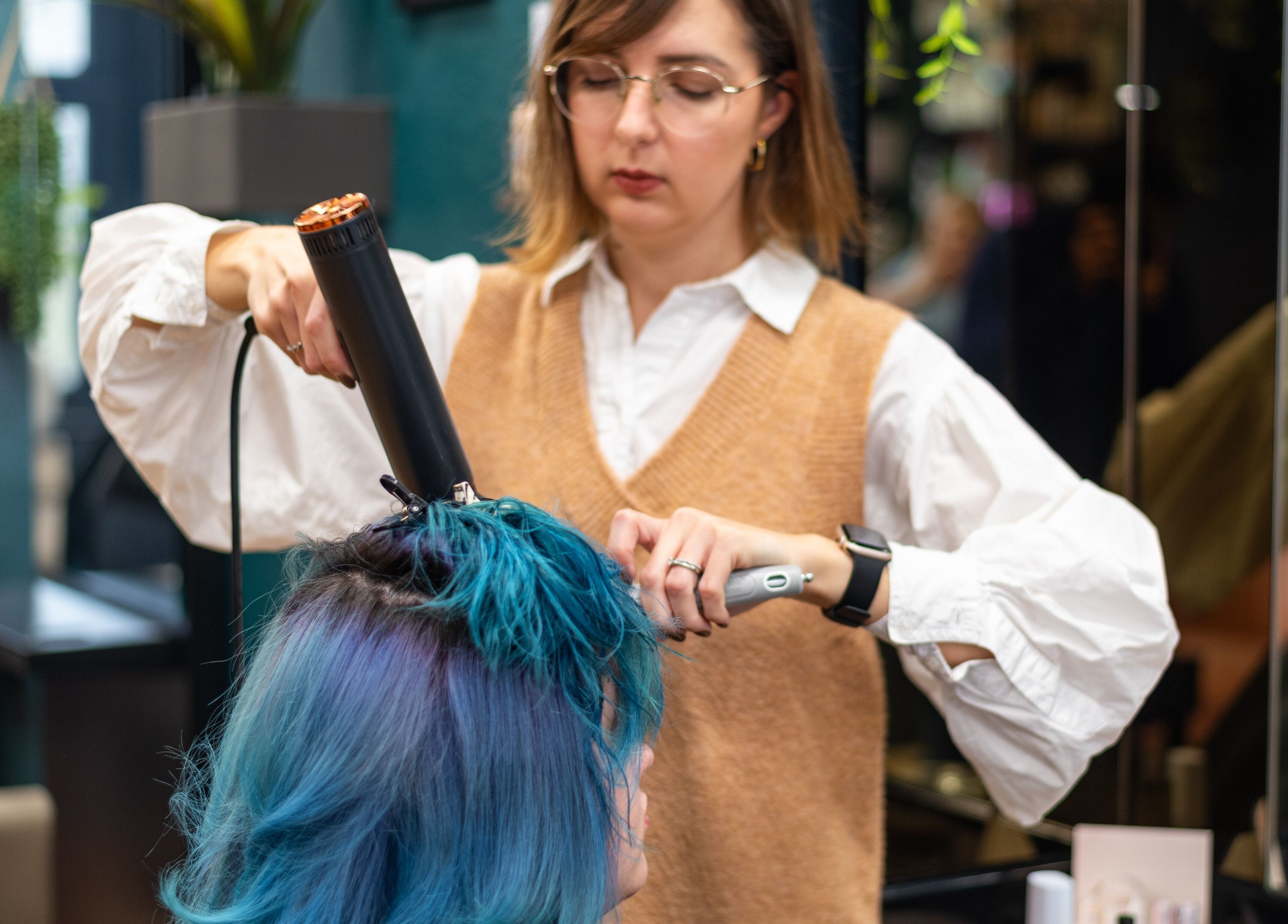 Professional hairstylist at The Knott Folkestone, England, GB, creating vibrant blue hairstyle.