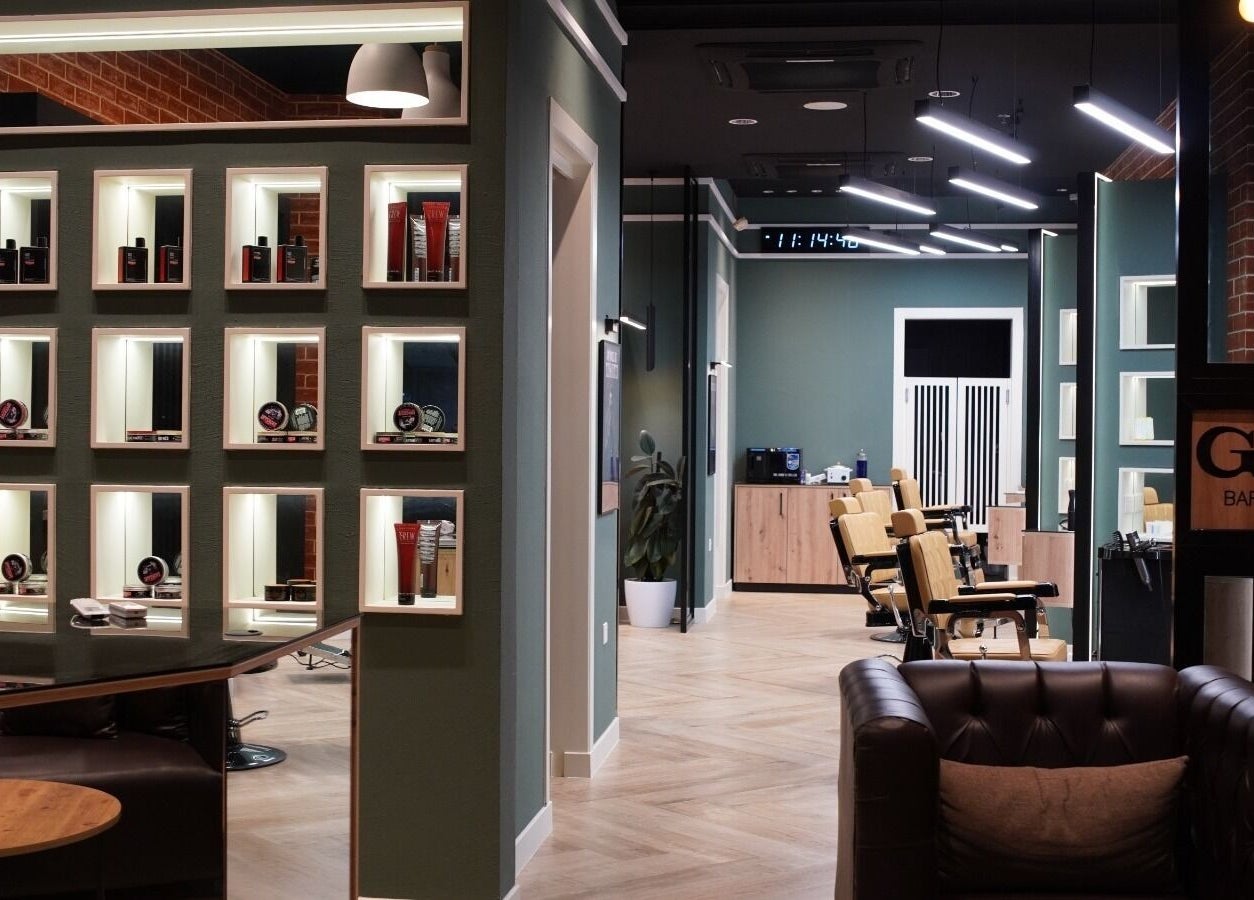 Modern seating and decor at Gil’s Barbershop, Al Khobar, Eastern Province, SA. Premium grooming products displayed.