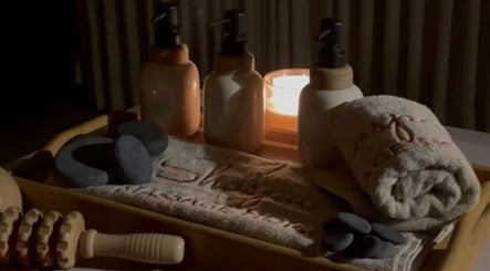 Relaxing spa setup at Shospa Home Service in Riyadh, Riyadh Province, SA, showcasing candles and massage tools.