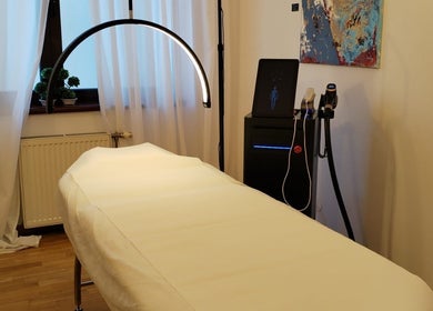Cabină de terapie la The Body Lab, București, București, RO, cu pat de masaj alb și iluminat ambiental.