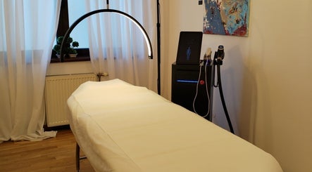 Cabină de terapie la The Body Lab, București, București, RO, cu pat de masaj alb și iluminat ambiental.