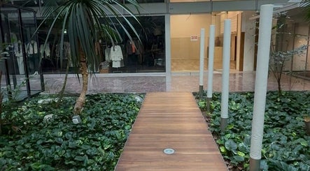 Modern entrance to Tsek Hair Studio, Opfikon, Zürich, CH, featuring lush greenery and stylish decor.