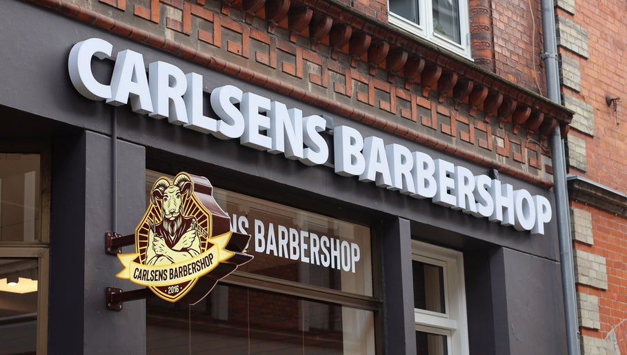 Carlsens Barbershop facade sign in Svendborg, DK. Classic barber styling on Kattesundet street.