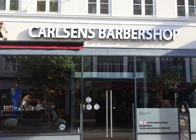 Exterior view of Carlsens Barbershop on Kongensgade, Odense, DK, showcasing the stylish entrance.