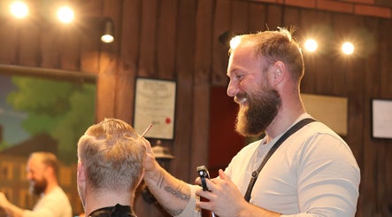 Barber at Carlsens Barbershop (Odense • Kongensgade) styling a client's hair. Located in Odense, DK.