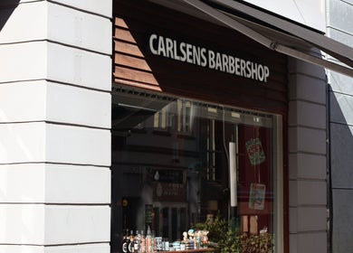 Front view of Carlsens Barbershop on Frederiksgade, Aarhus, DK, showcasing its inviting entrance.