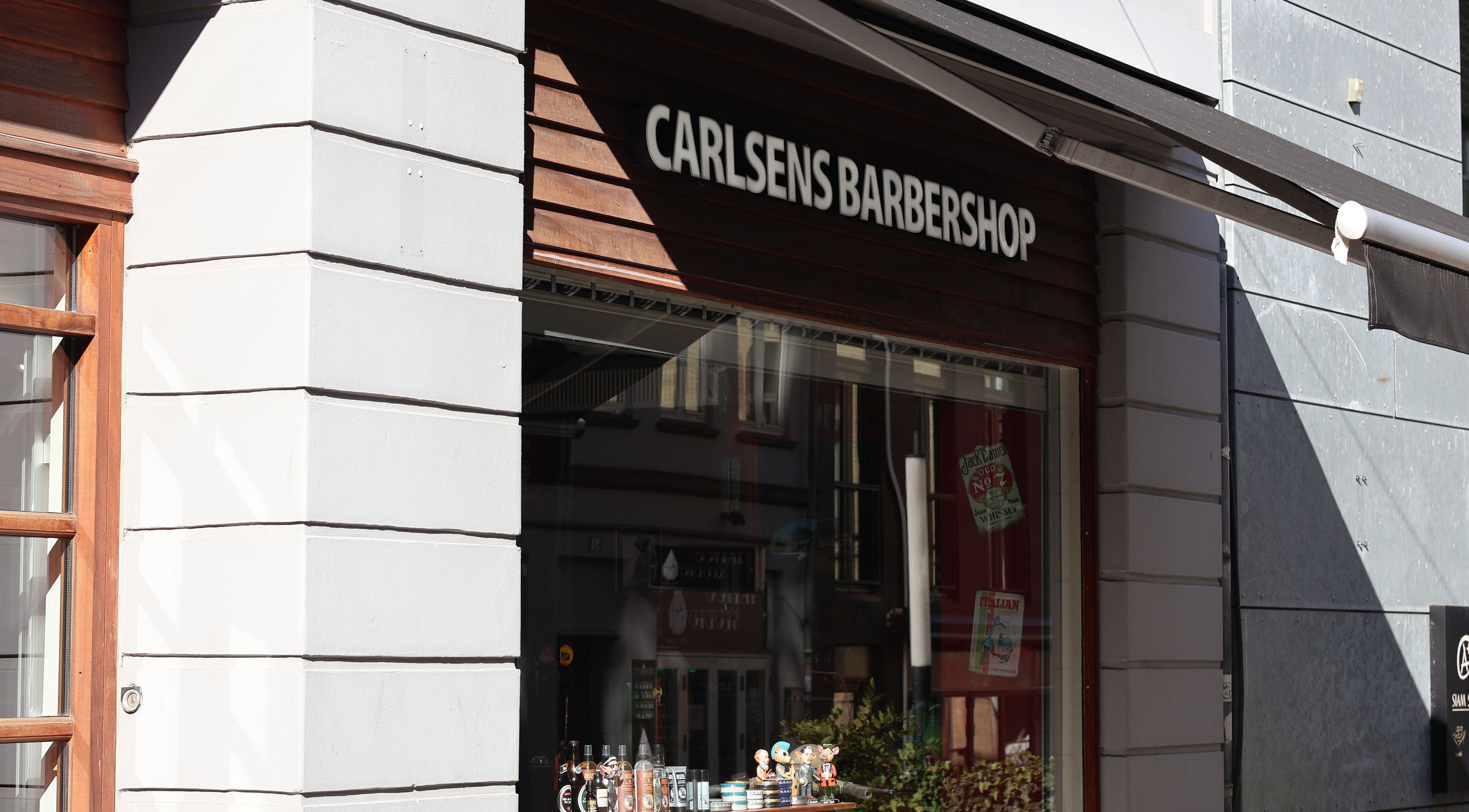 Front view of Carlsens Barbershop on Frederiksgade, Aarhus, DK, showcasing its inviting entrance.