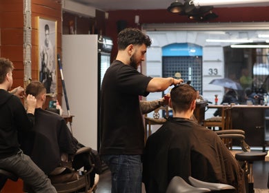 Stylists at work inside Carlsens Barbershop (Aarhus • Frederiksgade), Aarhus, DK, offering expert haircuts.