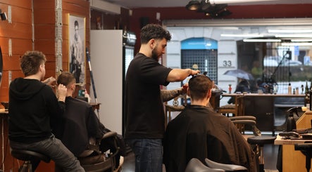 Stylists at work inside Carlsens Barbershop (Aarhus • Frederiksgade), Aarhus, DK, offering expert haircuts.
