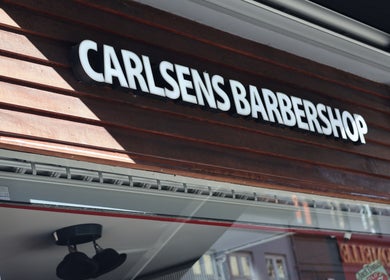 Storefront sign of Carlsens Barbershop, Aarhus • Frederiksgade, Aarhus, DK, showcasing modern style.