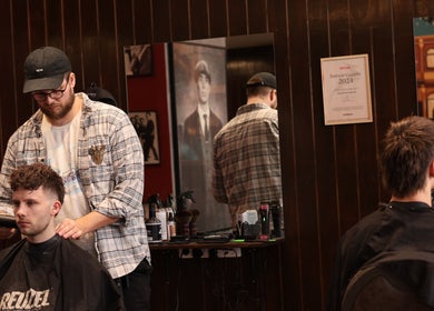 Frisør klipper kunde hos Carlsens Barbershop på Vesterbrogade, København, Denmark, DK.