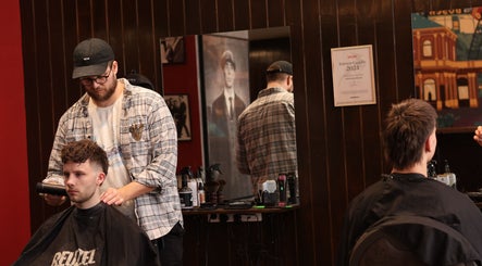 Frisør klipper kunde hos Carlsens Barbershop på Vesterbrogade, København, Denmark, DK.