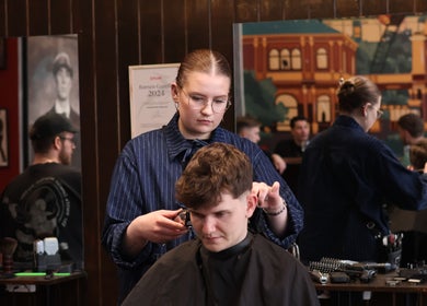 Frisør klipper kunde hos Carlsens Barbershop, Vesterbrogade, København, Denmark, DK.