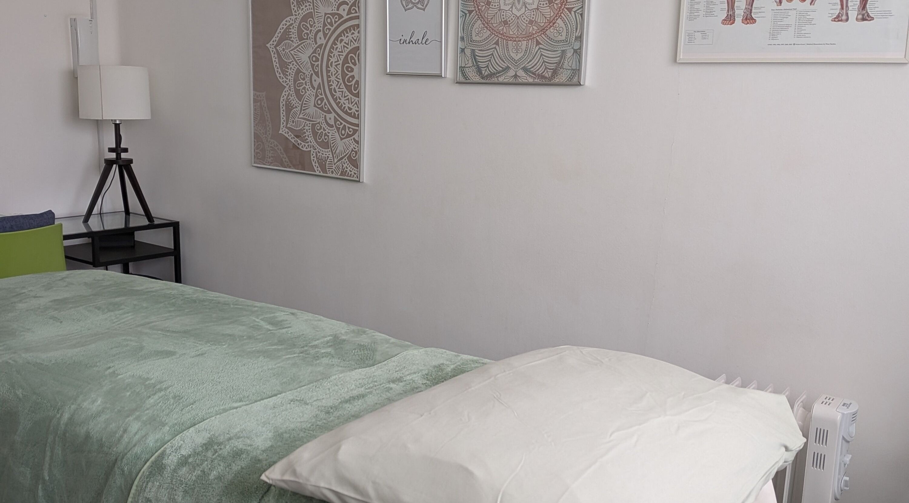 Cozy massage room at Via Massaje in London, England, GB with calming decor and soft lighting.