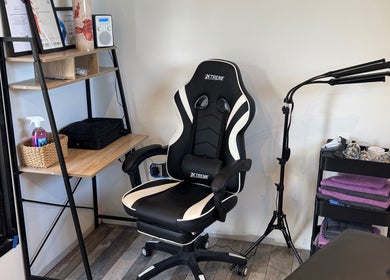 Comfortable massage chair at NG Sports Massage Ballyclare, Doagh, Northern Ireland, GB with equipment nearby.