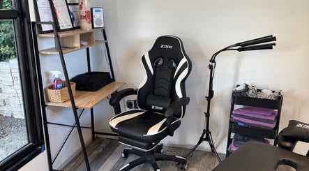 Comfortable massage chair at NG Sports Massage Ballyclare, Doagh, Northern Ireland, GB with equipment nearby.
