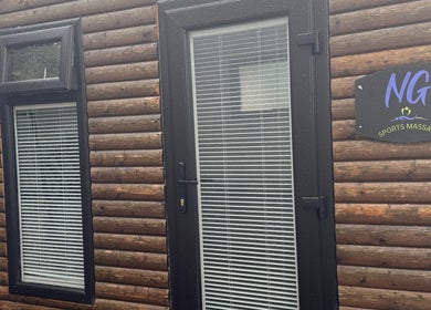 Wooden log cabin exterior of NG Sports Massage Ballyclare, located in Doagh, Northern Ireland, GB.