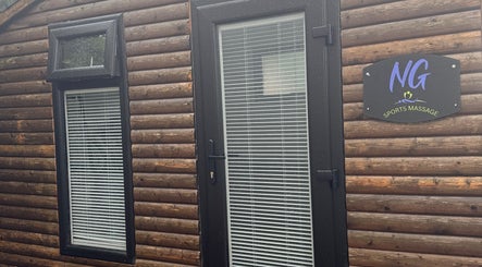 Wooden log cabin exterior of NG Sports Massage Ballyclare, located in Doagh, Northern Ireland, GB.