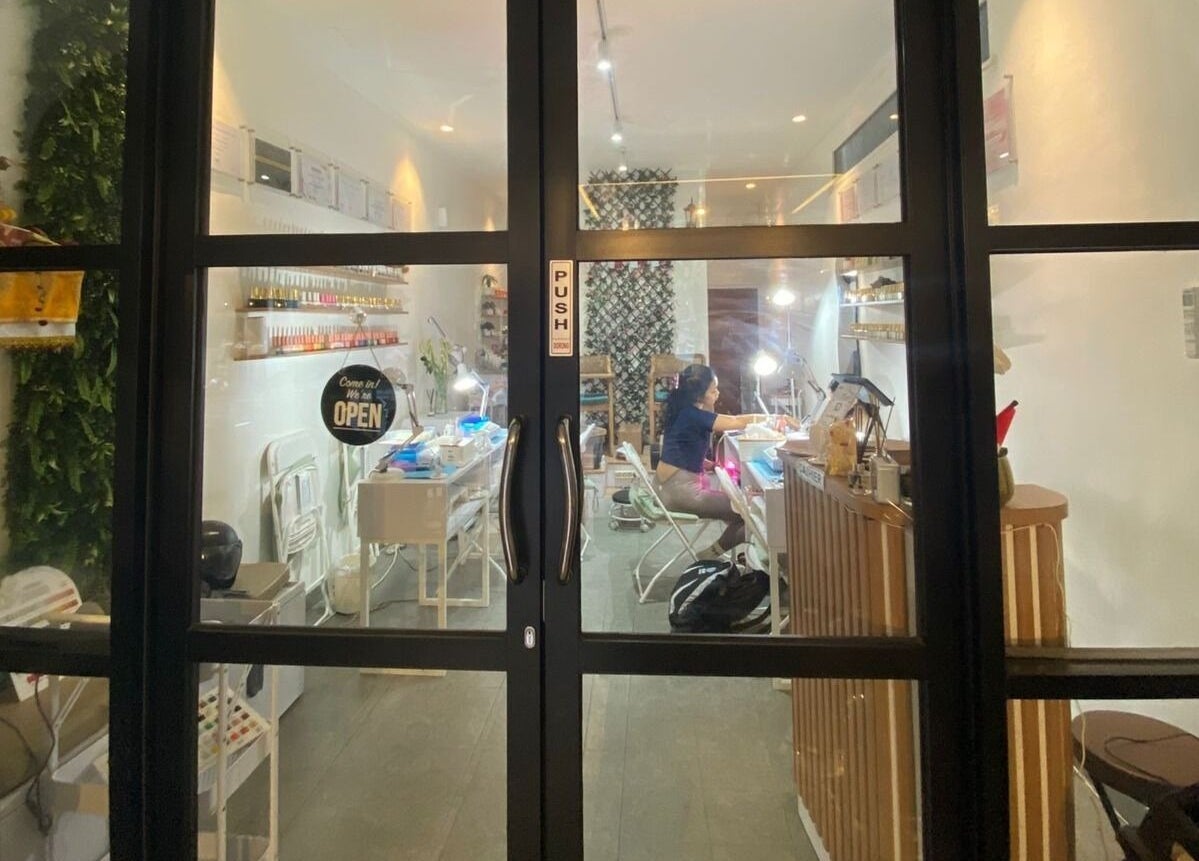 View through glass doors into Nail Lesss Monkey Forest salon in Bali, Bali, ID, showcasing a welcoming interior.