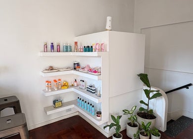 Product display at Ramos Beauty, Buenos Aires, featuring skincare items and plants in a cozy corner.