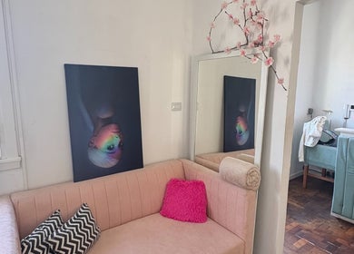 Stylish lounge area at Ramos Beauty, Buenos Aires with modern decor, pink sofa, artwork and floral accents.