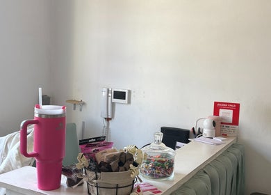 Reception desk at Ramos Beauty in Buenos Aires with pink tumbler and decor for a warm welcome.