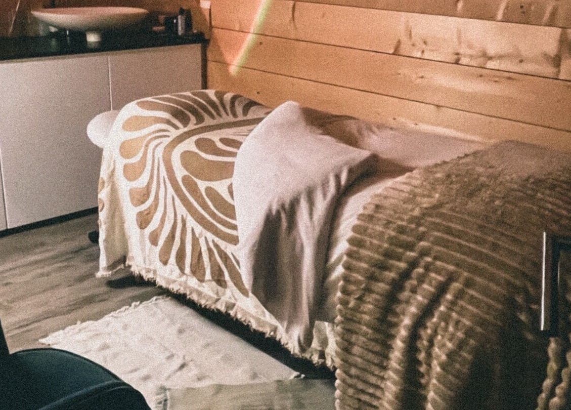 Salle de massage paisible à Marion PRĀNA, Crespières, Île-de-France, FR, avec draps élégants sur table de soin.