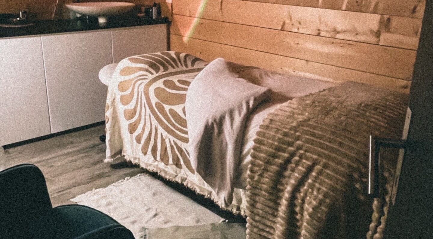 Salle de massage paisible à Marion PRĀNA, Crespières, Île-de-France, FR, avec draps élégants sur table de soin.