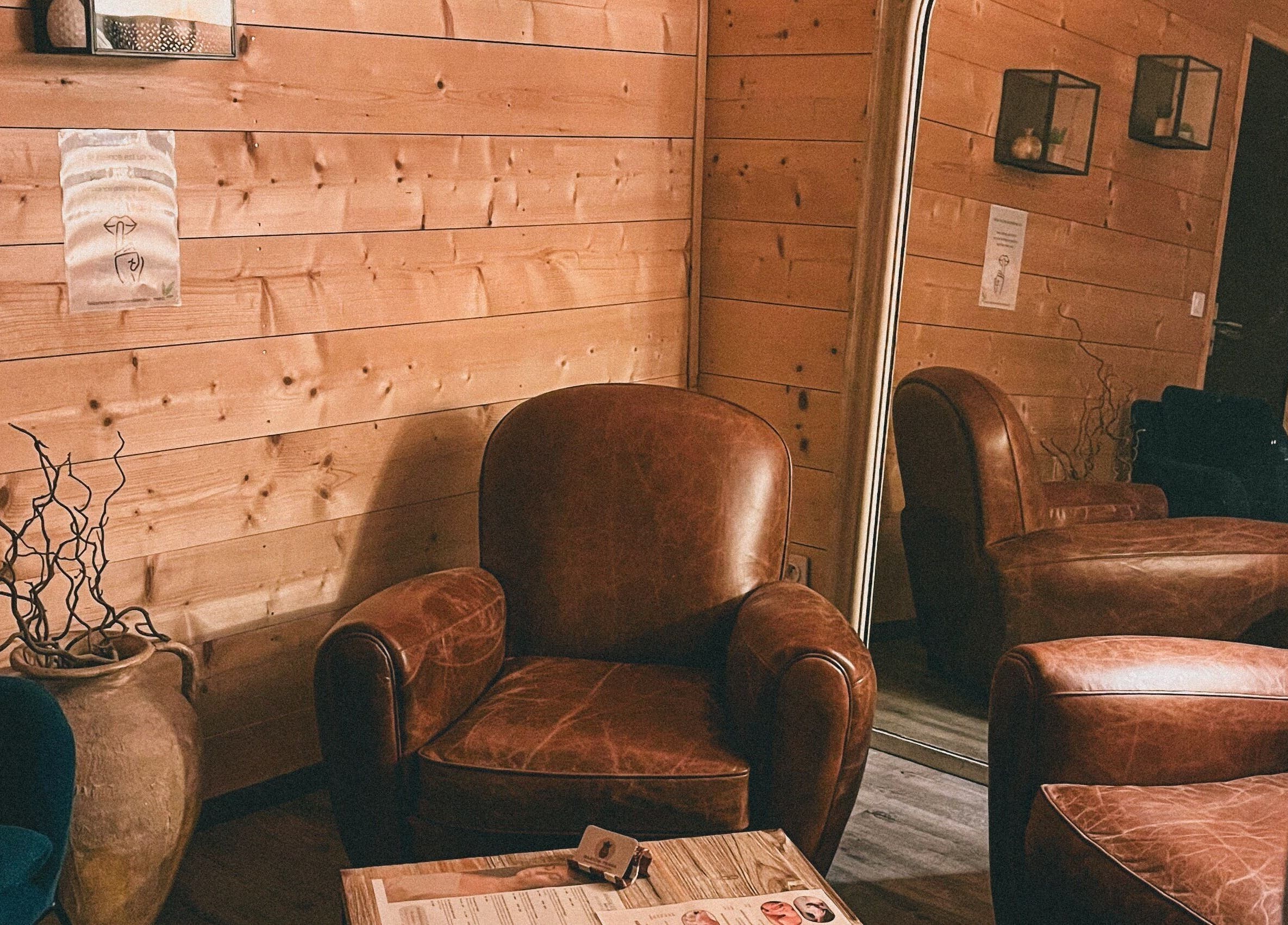 Coin salon en cuir à Marion PRĀNA, Crespières, Île-de-France, FR. Ambiance chaleureuse avec miroir et décoration bois.