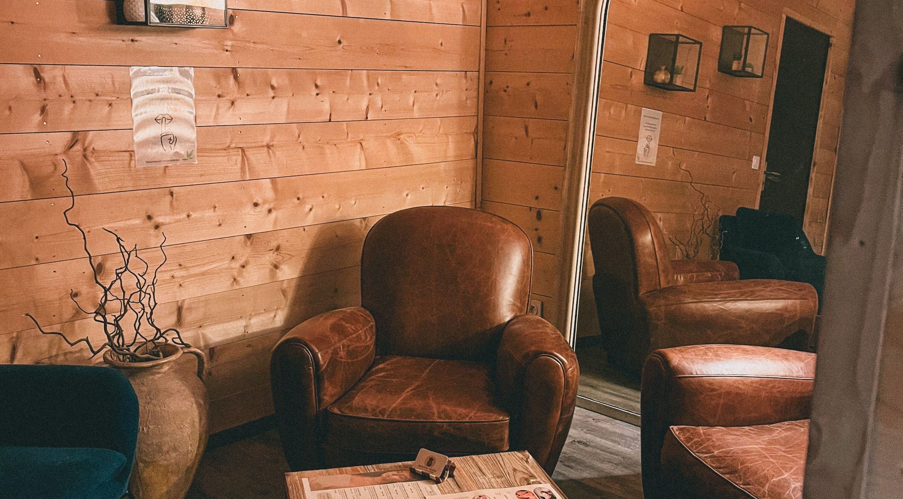Coin salon en cuir à Marion PRĀNA, Crespières, Île-de-France, FR. Ambiance chaleureuse avec miroir et décoration bois.