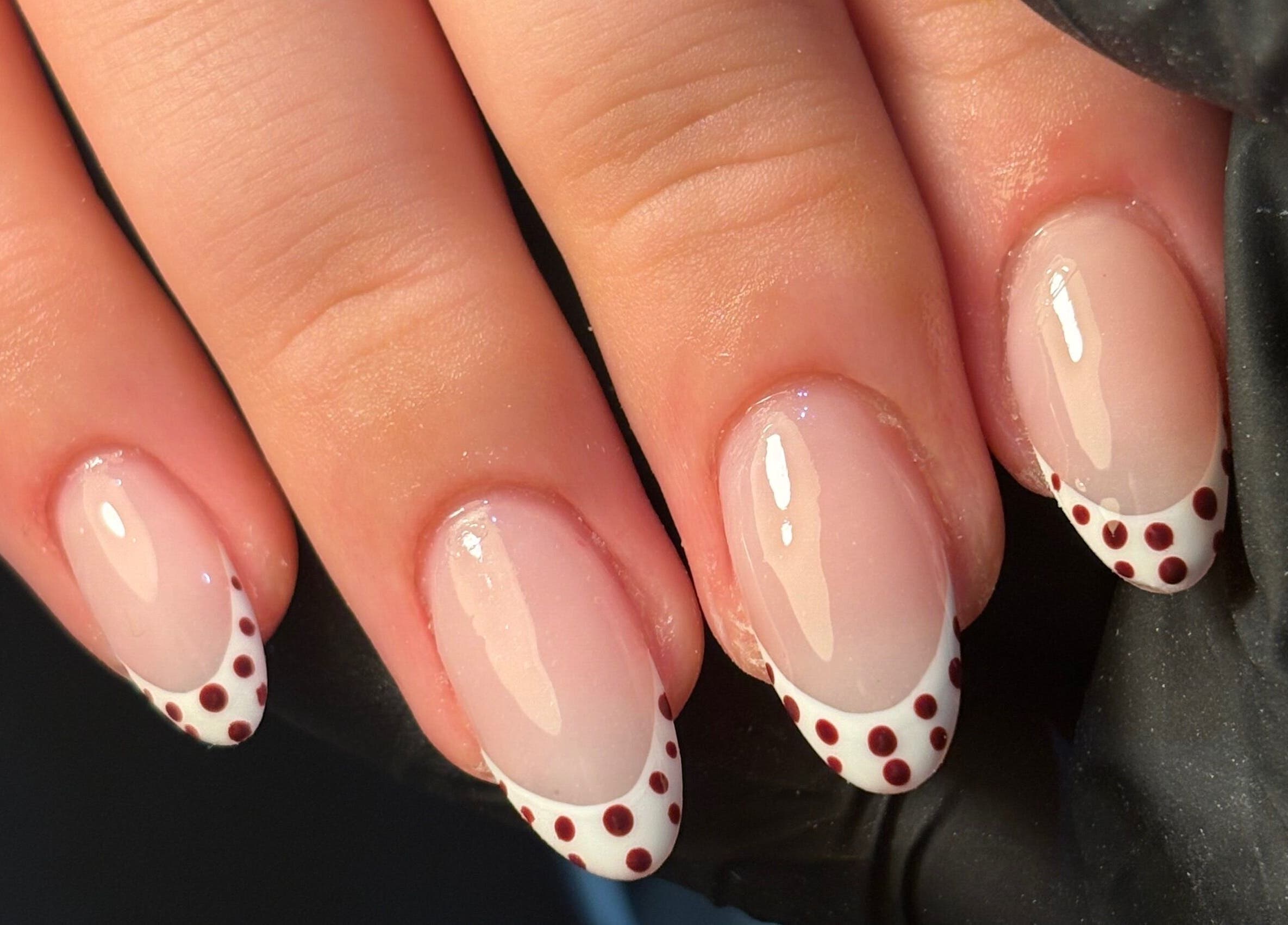 Elegant nail art with polka dots by Jess Ellis in Birkenhead, England, GB, showcasing glossy nails.