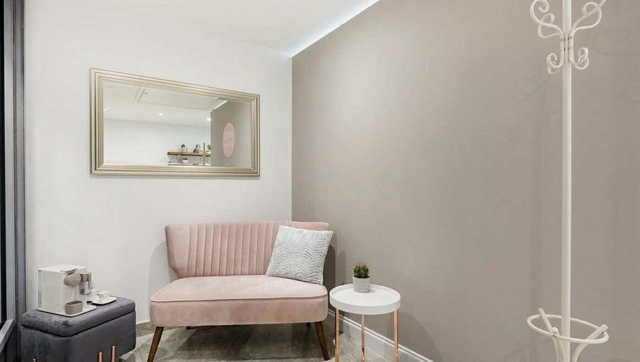 Stylish waiting area with pink velvet sofa at YM London, London, England, GB.