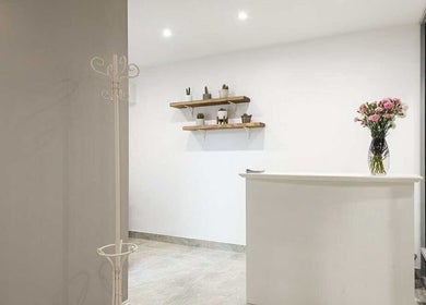 Elegant reception area at YM London, London, England, GB featuring minimalist decor and floral accents.