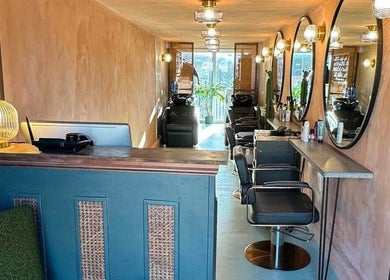 Cozy and elegant salon interior at Sher Arcana Studios, London, England, GB, featuring stylish decor and mirrors.