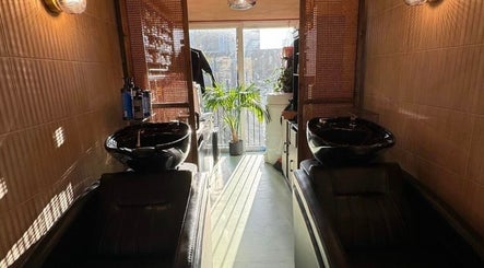 Elegant hair wash stations at Sher Arcana Studios, London, England, GB, with soft lighting and lush plants.